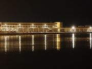 Veduta notturna del prospetto nord con le luci che si specchiano nel mare Veduta notturna del prospetto nord con le luci che si specchiano nel mare